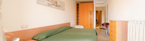 a bedroom with a green bed and a desk at Caprice Appartamenti Vacanze in Diano Marina