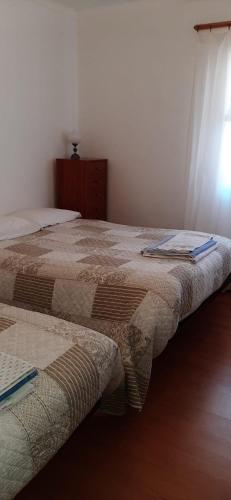 GouveiaにあるApartamento Abrilのベッド2台が隣同士に設置された部屋です。