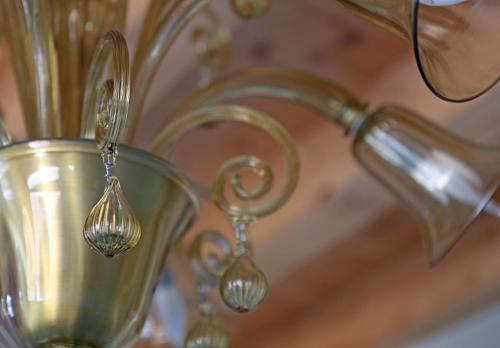 a gold vase with spoons in it next to a sink at Shuttered Dreams Murano Venice in Murano