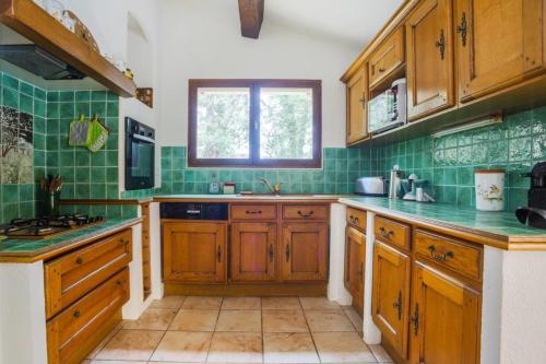 une cuisine avec des placards en bois et du carrelage vert dans l'établissement Villa 6 guests 30 min from Cannes - Private Pool, à Fayence