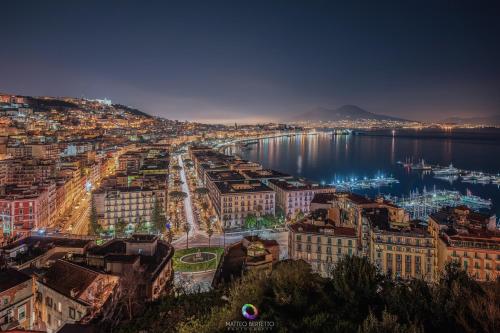 vista su una città con porto di notte di Suite Riviera 84 a Napoli