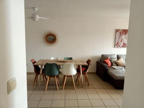 jadalnia ze stołem, krzesłami i kanapą w obiekcie Casa Maya quartier des pêcheurs terre sainte avec garage box w mieście Saint-Pierre