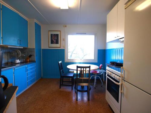 a kitchen with blue cabinets and a table and a window at House near the University in Ås - Ski in Ås