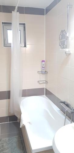 un bagno bianco con vasca e WC di Apartament Ana a Topliţa