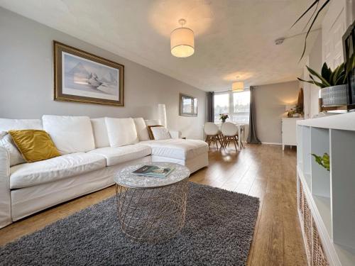 een woonkamer met een witte bank en een tafel bij Scandi Style Duplex Sleeps 6 in Linlithgow