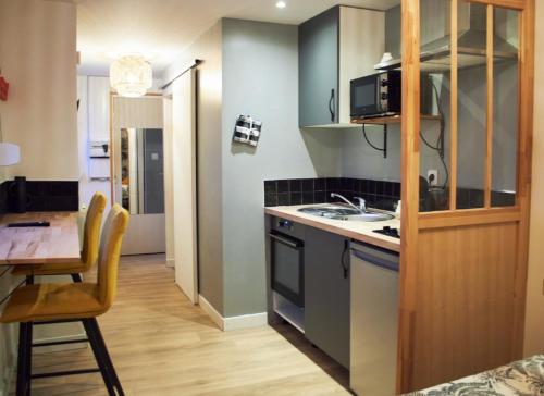 une petite cuisine avec une table et un micro-ondes dans l'établissement Studio Evasion, à Amiens