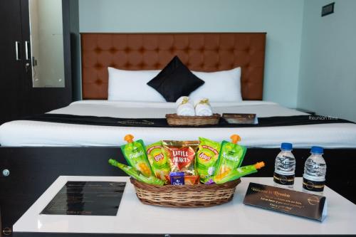 a hotel room with a bed and two baskets of snacks at Reunion Ocean Tides in Udupi