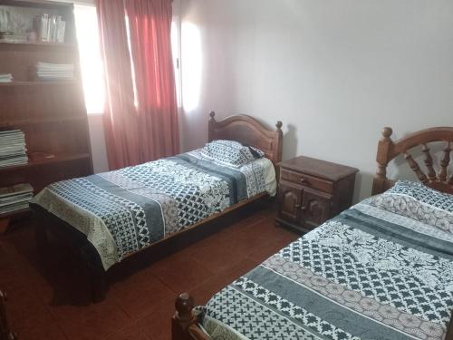 a bedroom with two beds and a dresser at Don Ricardo in San Salvador de Jujuy