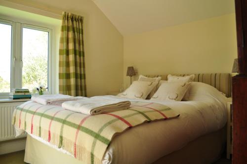 a bedroom with a bed with a blanket on it at Rose Cottage in Tunstall