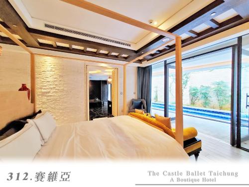 sypialnia z dużym łóżkiem i dużym oknem w obiekcie The Castle Ballet Taichung A Boutique Hotel w mieście Taizhong