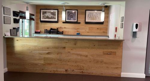 a wooden counter in a room with pictures on the wall at SureStay Plus Hotel by Best Western Vero Beach in Vero Beach