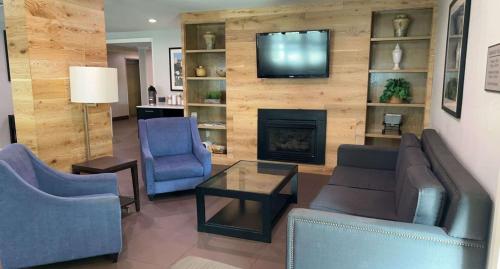 a living room with two chairs and a fireplace at SureStay Plus Hotel by Best Western Vero Beach in Vero Beach