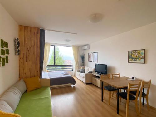 a living room with a couch and a table at Aspen studio Mountain retreat at Aspen Resort Golf Ski & Spa in Razlog