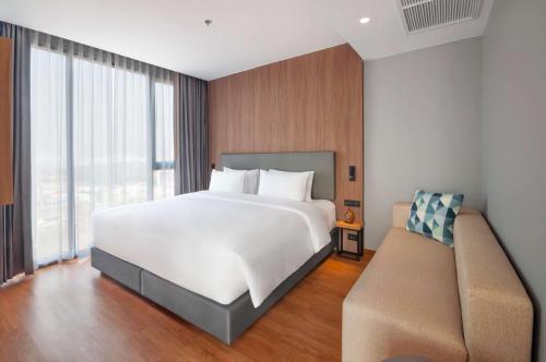 a bedroom with a large white bed and a couch at Best Western Chatuchak in Bangkok