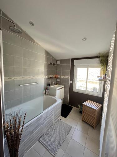 ein Badezimmer mit einer Badewanne und einem Waschbecken in der Unterkunft Superbe Loft, dégustations vignoble familial in Villars-en-Pons