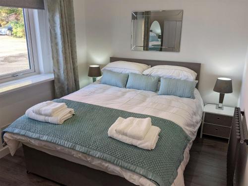 a bedroom with a large bed with towels on it at Strathclyde Cottage North in Skelmorlie