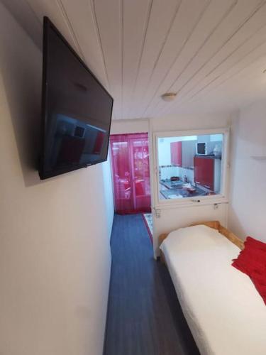 a bedroom with a bed and a flat screen tv on the wall at Appartement fonctionnel et équipé en RDC avec petite terrasse couverte au calme in Franqueville-Saint-Pierre
