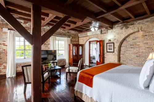 um quarto com uma cama grande numa parede de tijolos em Copper and Lumber Store Hotel em English Harbour Town