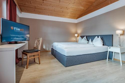 a bedroom with a bed and a flat screen tv at Active Chalet in Maria Alm am Steinernen Meer