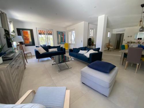een woonkamer met banken en stoelen en een televisie bij La Bastide Blanche Magnifique villa 5 étoiles 5 chambres et piscine privée sur 6500 m VAR in Lorgues