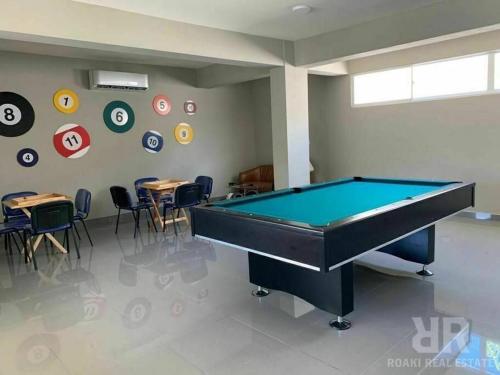 a pool table in a room with tables and chairs at Mountain View Cibao in Santiago de los Caballeros