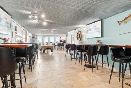un comedor con sillas y un bar en un restaurante en Lowes Wharf Marina Inn, en Sherwood