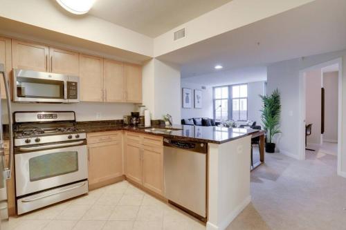 a kitchen with stainless steel appliances and wooden cabinets at Upscale Comfort Next to Metro and Dining in Arlington