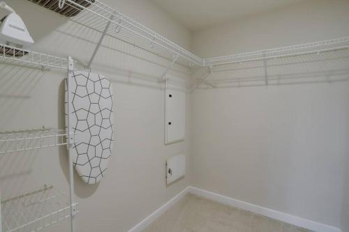 a white walk in closet with white walls and white shelves at Beautiful 2 BR Apartment At Pentagon City With Gym in Arlington