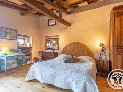 a bedroom with a large bed and a desk at Maison charmante près de Montreuil Bellay avec Wifi et Animaux admis - FR-1-622-53 in Brossay