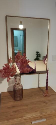 a mirror on a wall with a vase on a table at Large and modern apartment in the centre of Malta in Mosta