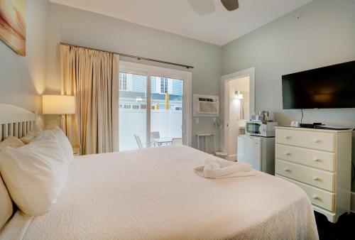 Un dormitorio con una gran cama blanca y una ventana en The Inn at Sea Chambers, en Ogunquit