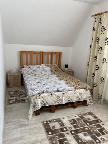een slaapkamer met een bed en gordijnen en een tapijt bij Cabana Șirnea in Şirnea