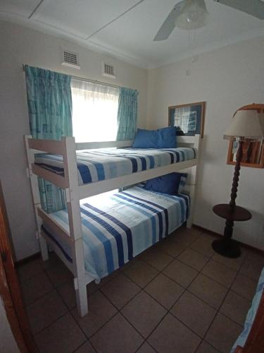 two bunk beds in a room with a window at Neptune corner in Hibberdene