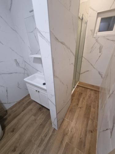 a bathroom with white marble walls and a mirror at Batea 2 in Seline