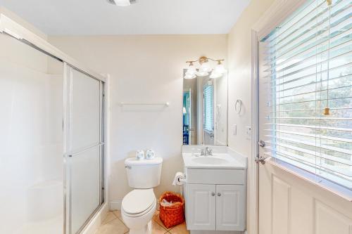 a bathroom with a toilet and a sink and a mirror at Pamlico Sunset #8-9 in Avon