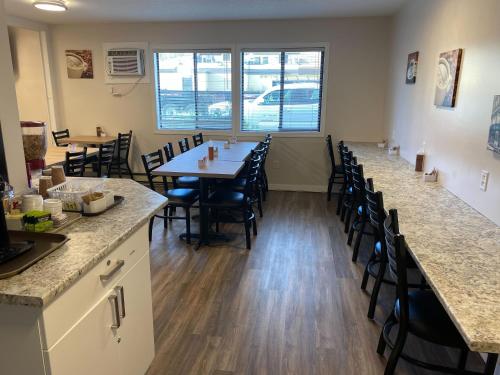 a dining room with a long table and chairs at Dilworth Inn Kelowna in Kelowna