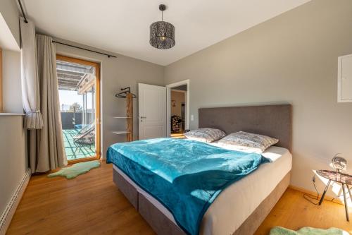 a bedroom with a bed with a blue blanket on it at Residenz am Aichwaldsee - mountainview and near lake in Unteraichwald