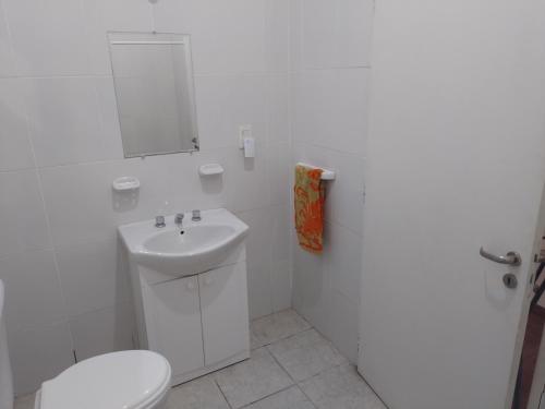 uma casa de banho branca com um WC e um lavatório em Pasteur B&B em Godoy Cruz