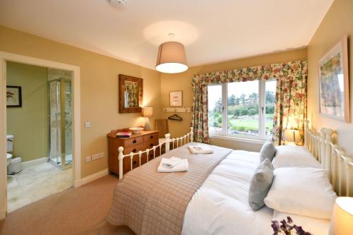 Un dormitorio con una cama grande y una ventana en Cedar Lodge, en Portpatrick
