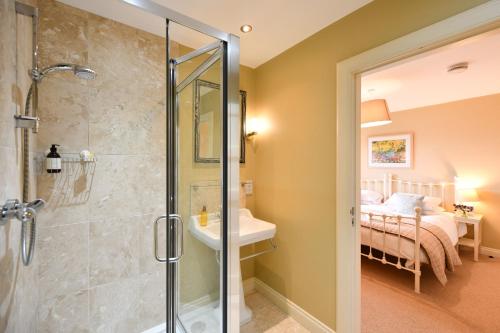 a bathroom with a walk in shower next to a bedroom at Cedar Lodge in Portpatrick