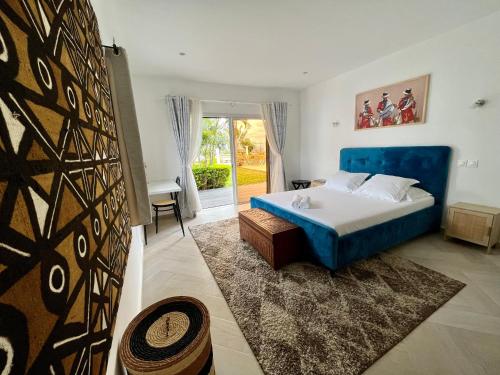 a bedroom with a blue bed and a window at COCODY ROC in Ambohidratrimo
