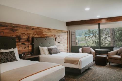 a hotel room with two beds and a chair at Huntley Lodge at Big Sky Resort in Big Sky