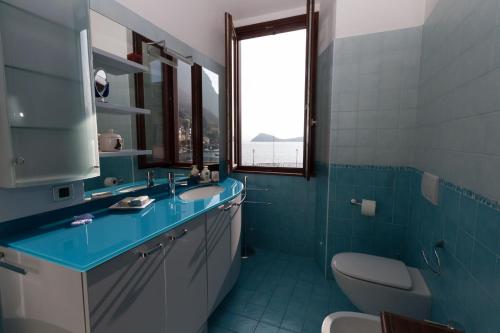 een badkamer met een wastafel, een toilet en een raam bij Menaggio Marina in Menaggio
