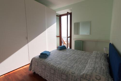een slaapkamer met een bed met twee blauwe handdoeken erop bij Menaggio Marina in Menaggio