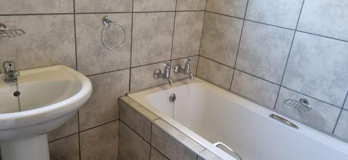 un baño con bañera y lavabo en Rand Self-catering Accommodation, en Carolina