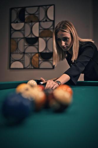 a woman looking at a ball on a pool table at Das Kronberg Hotel - Adults Only - inkl Soft- und Heißgetränkeflat in Bodenmais