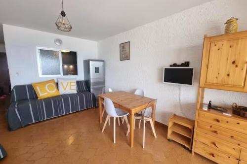 een woonkamer met een tafel en een bank bij Studio of 30m with nice view on the sea in Six-Fours-les-Plages