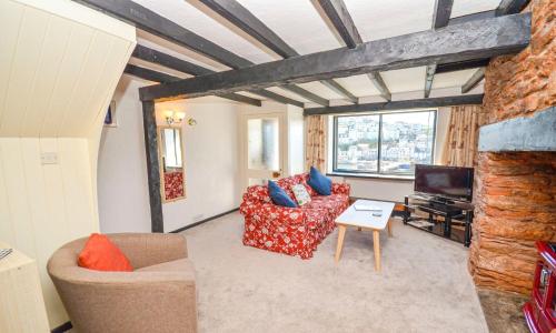 a living room with a couch and a tv at Sea Nook in Brixham