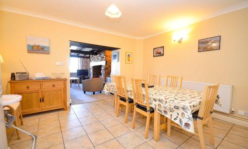 a dining room with a table and chairs and a kitchen at Sea Nook in Brixham