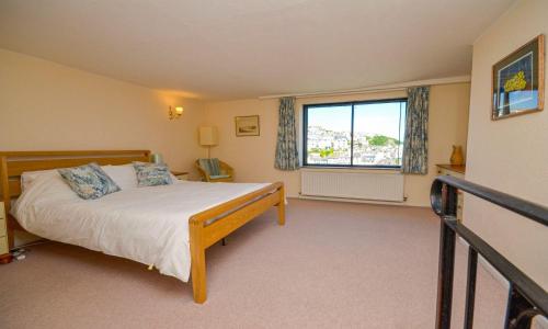 a bedroom with a bed and a window at Sea Nook in Brixham